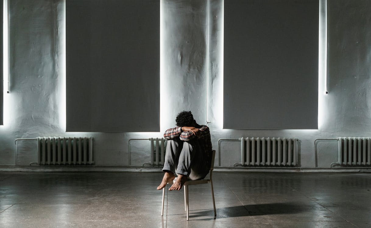 Free A Frightened Man Sitting Alone on a Chair Stock Photo