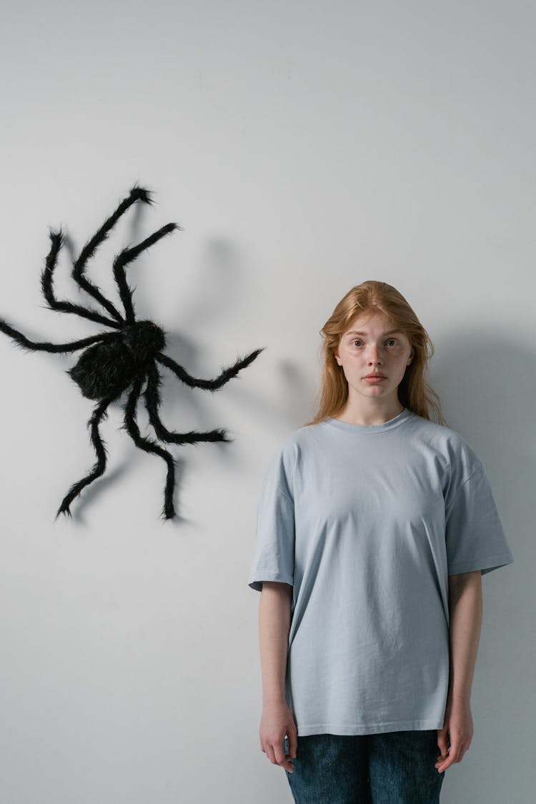 A Woman Afraid Of Big Spider Hanging On A Wall