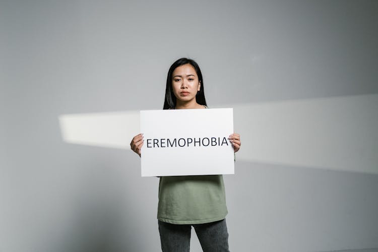 A Woman Holding A Sign Of Eremophobia