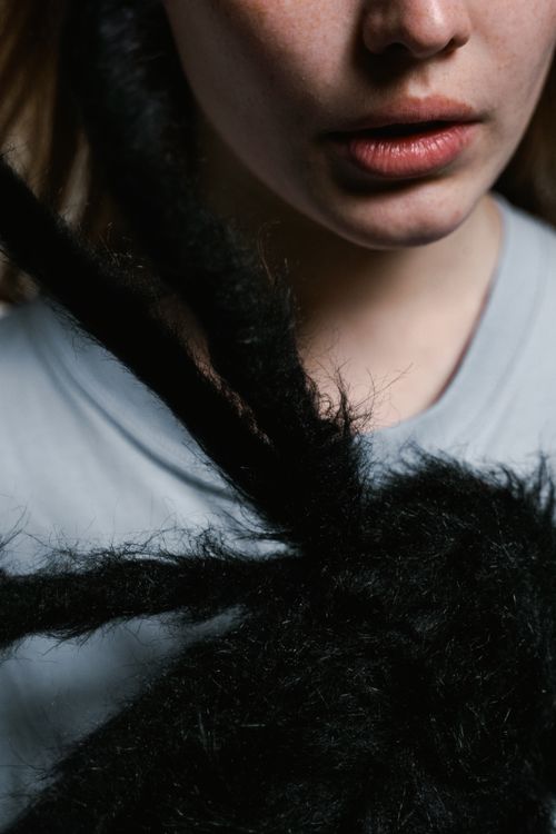 Free A close-up of a woman's face with a furry spider, highlighting themes of fear or arachnophobia. Stock Photo