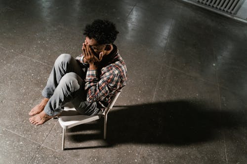 A Frightened Man Sitting Alone on a Chair