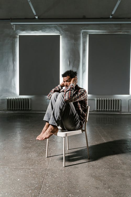 A Frightened Man Sitting Alone on a Chair