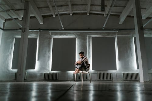Free A Frightened Man Sitting Alone on a Chair Stock Photo