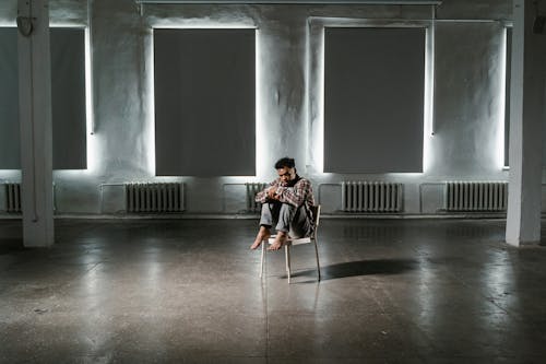 A Frightened Man Sitting Alone on a Chair