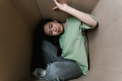 A Fearful Woman Having Claustrophobia in a Cardboard Box