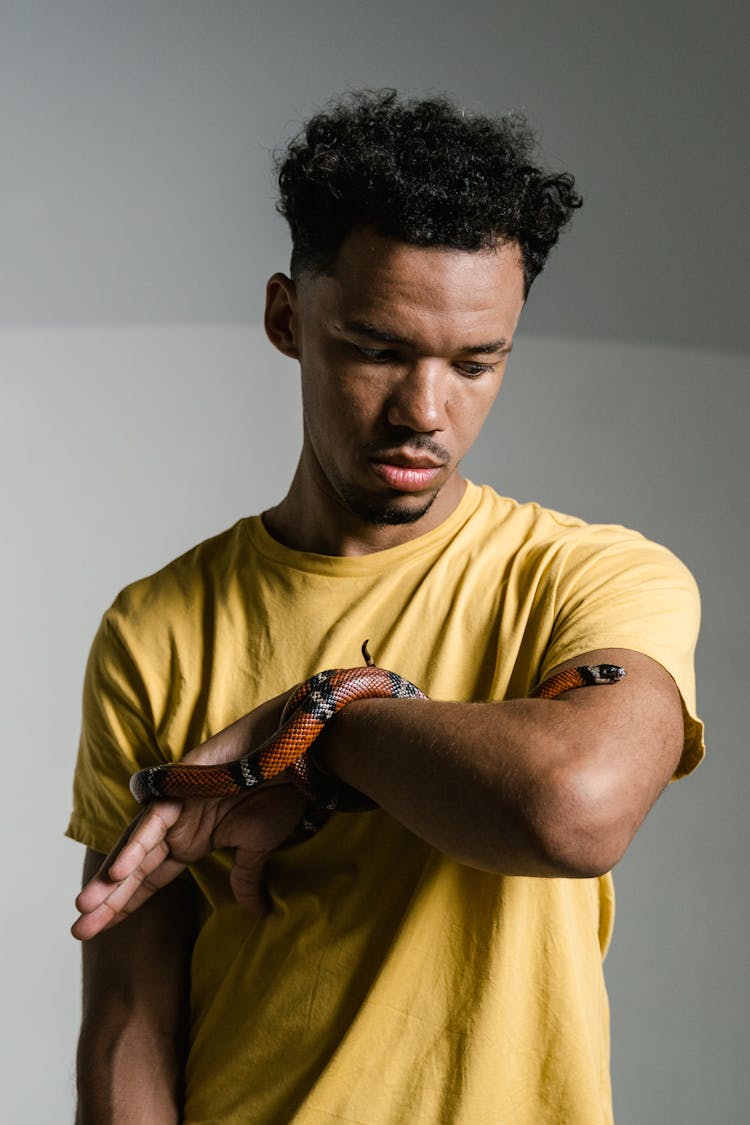 Man In Yellow Shirt Overcoming His Fear Of Snakes