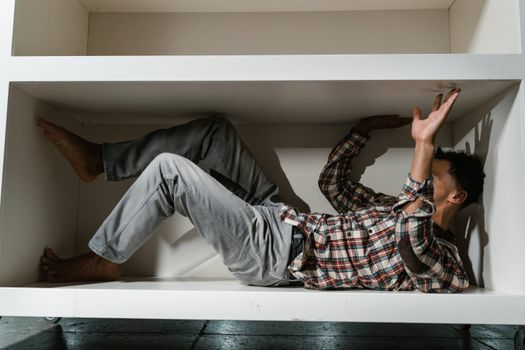 A Fearful Man Having Claustrophobia in a Cabinet