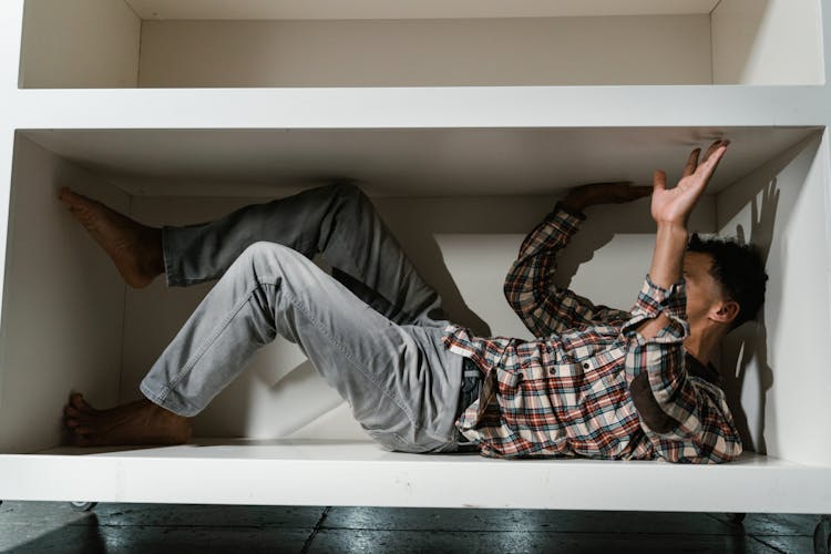 A Fearful Man Having Claustrophobia In A Cabinet