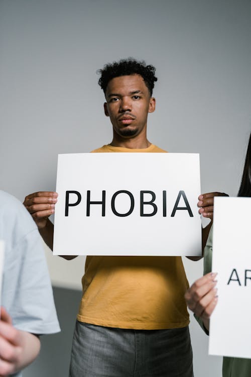 A Man Holding a Sign of Phobia