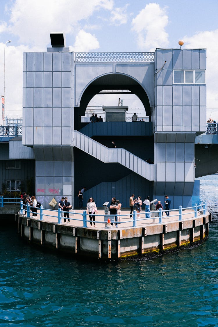 People On Pier Near Modern Geometric Building