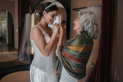 Free Bride and grandmother share a tender moment on wedding day indoors. Stock Photo