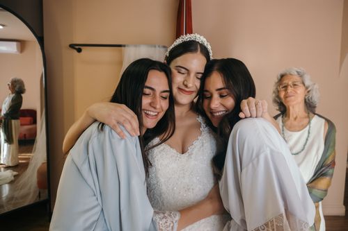 Free A bride and bridesmaids share a joyful embrace before the wedding ceremony. Stock Photo