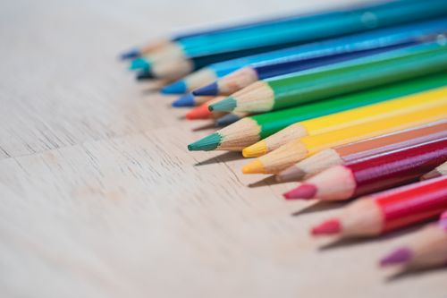Free A close-up of sharpened colored pencils arranged on a wooden surface, ideal for art projects. Stock Photo