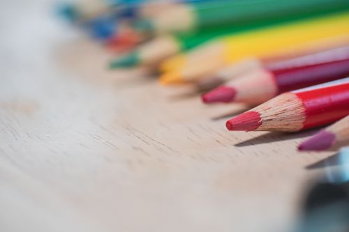 Free Close-up of vibrant colored pencils laid out on a wooden table, sharpened and ready for use. Stock Photo