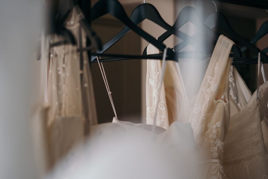 Curated collection of designer wedding gowns on a rack Curated collection of designer wedding gowns on a rack