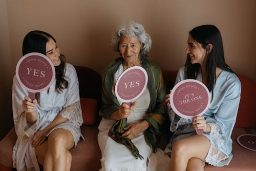 Bridesmaids and Grandmother Sitting and Holding Signs 