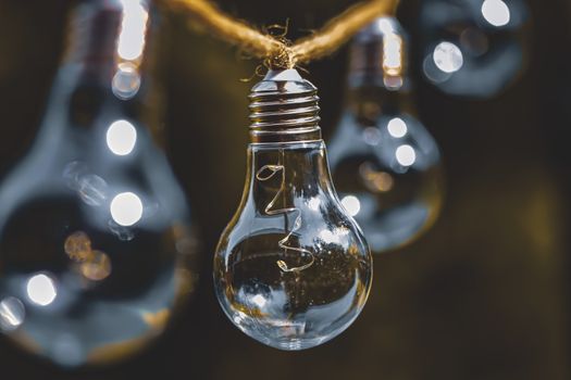 A close-up of decorative hanging lightbulbs with selective focus, glowing warmly.