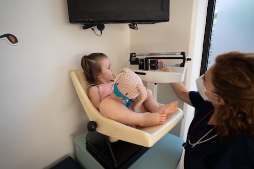 Free Nurse Weighing a Little Girl at a Pediatricians Office Stock Photo