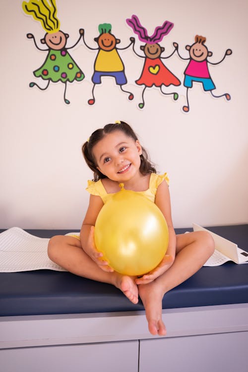 A Cute Girl Holding a Yellow Balloon