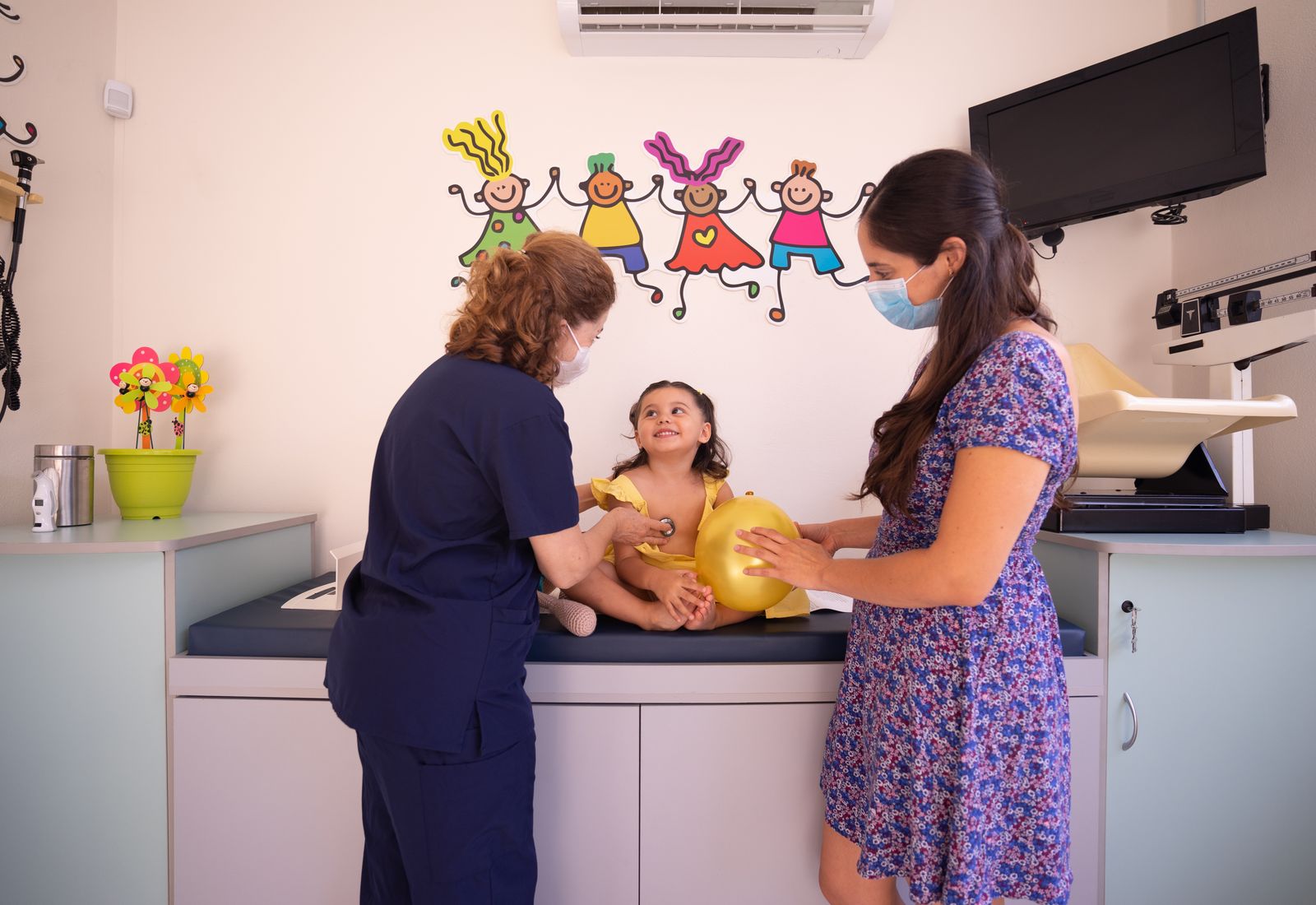 Doctor checking a young child at a paediatric clinic with a parent present