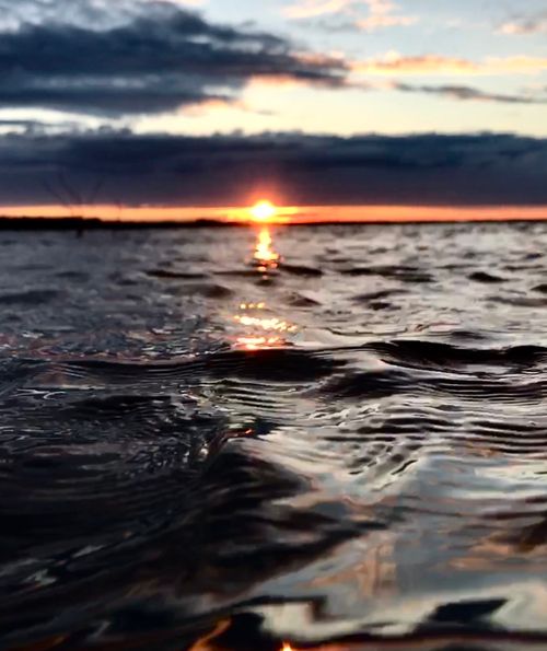 Free Vivid sunset over the ocean with dramatic clouds and rippling waves. Captured on iPhone 7. Stock Photo