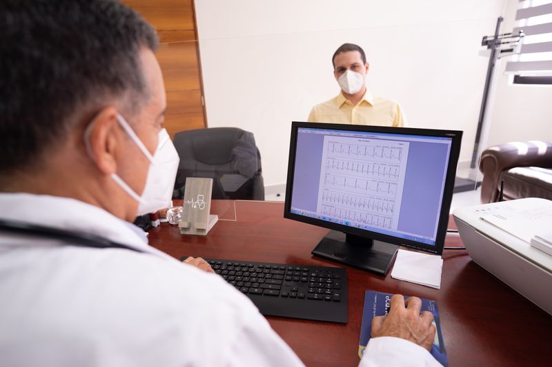 Doctor looking at a computer screen in a dimly lit clinic