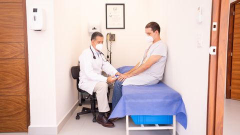 Doctor checking patient's vitals in a clinical setting for health consultation.
