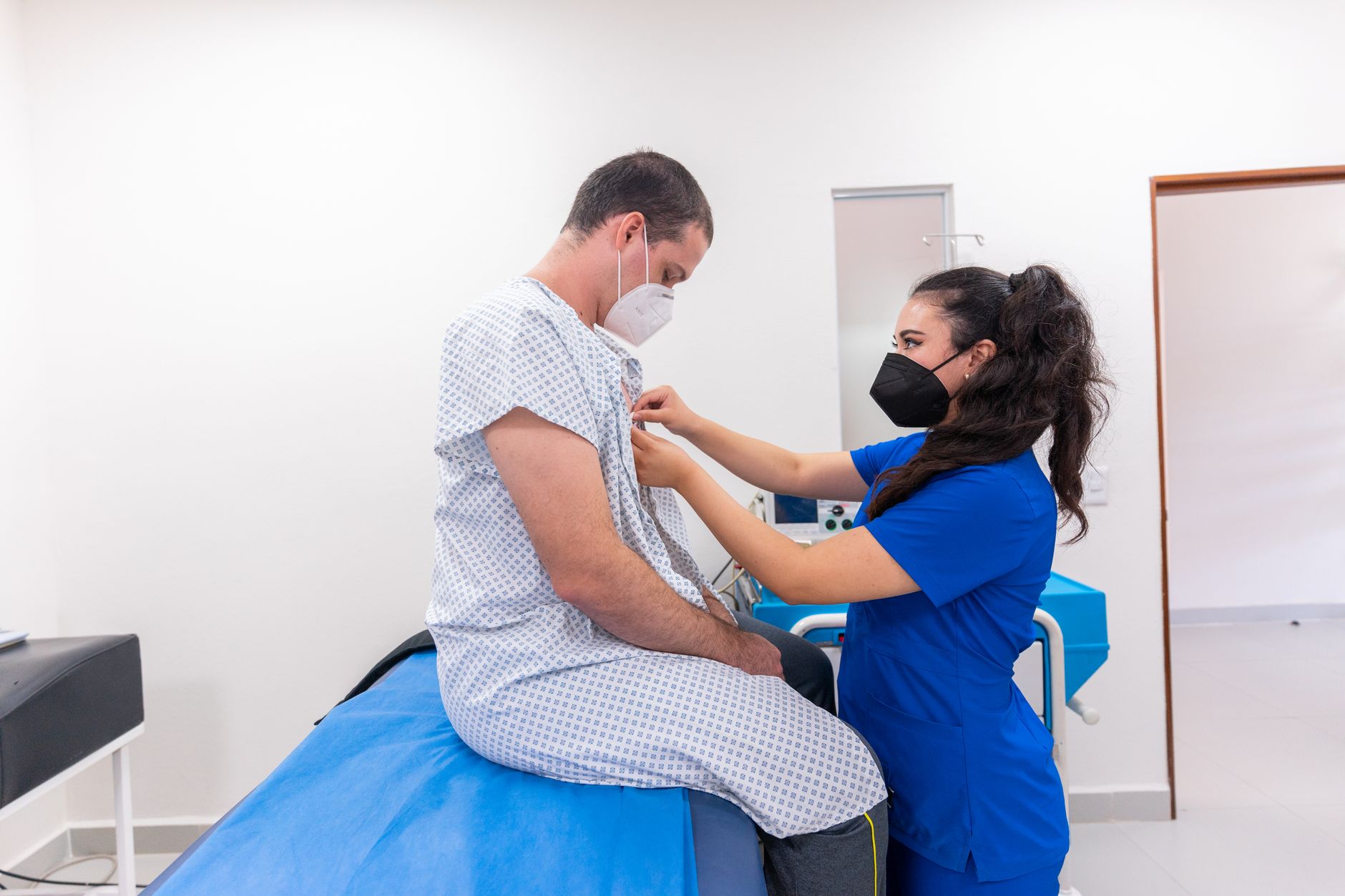 Nurse assisting patient with medical examination in a hospital setting.