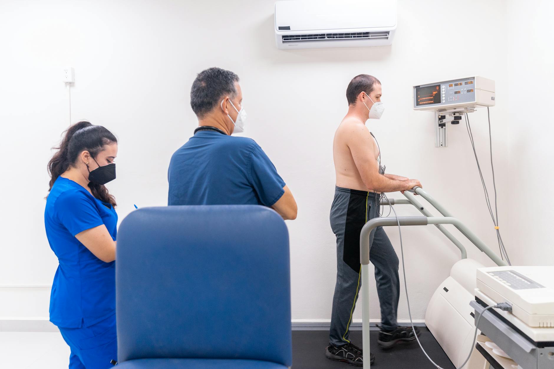 Patient undergoing a cardiac stress test in a medical clinic with a healthcare team.