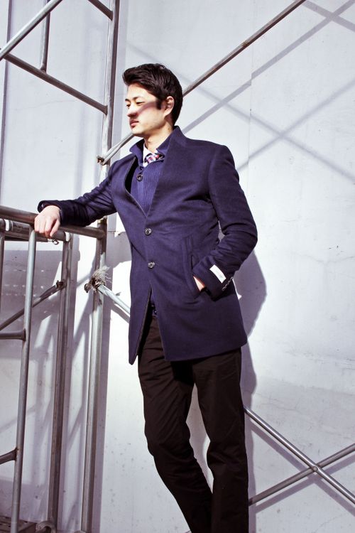 Free Stylish man in blazer posing on scaffolding in Seoul, emphasizing modern fashion. Stock Photo