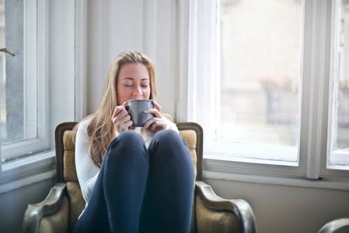 女人抱著灰色的陶瓷杯