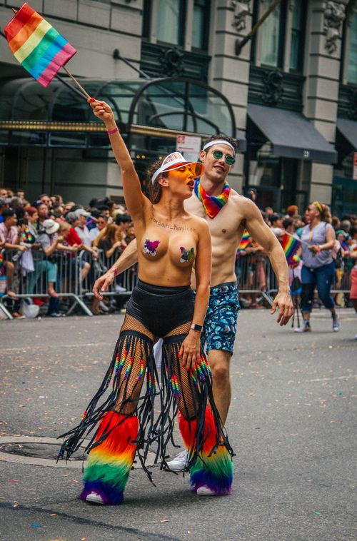 Free Vibrant Pride parade participants celebrating with rainbow flags in New York City. Stock Photo