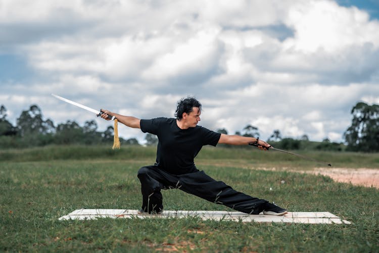 Man Practicing Martial Arts With Swords