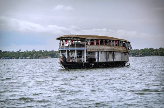 Scenic view of a traditional houseboat on the serene backwaters of Alappuzha, Kerala, India.