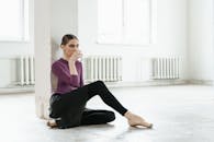 Woman in Purple Long Sleeve Shirt and Black Pants Sitting on Floor