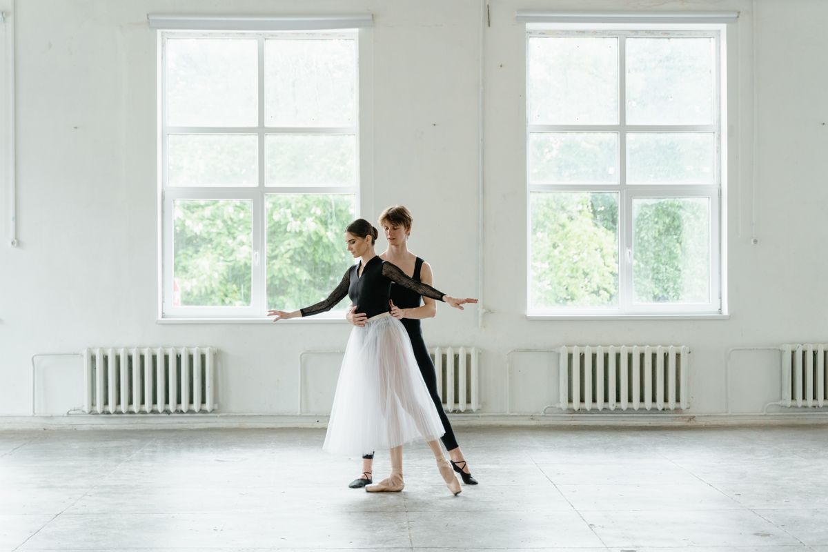 Dance partners rehearsing a lift in a bright studio