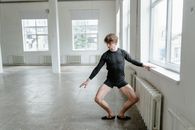 Man in Black Long Sleeve Shirt and Black Shorts Running on White Floor Tiles