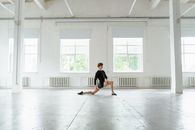 Man in Black T-shirt and Black Shorts Sitting on Floor