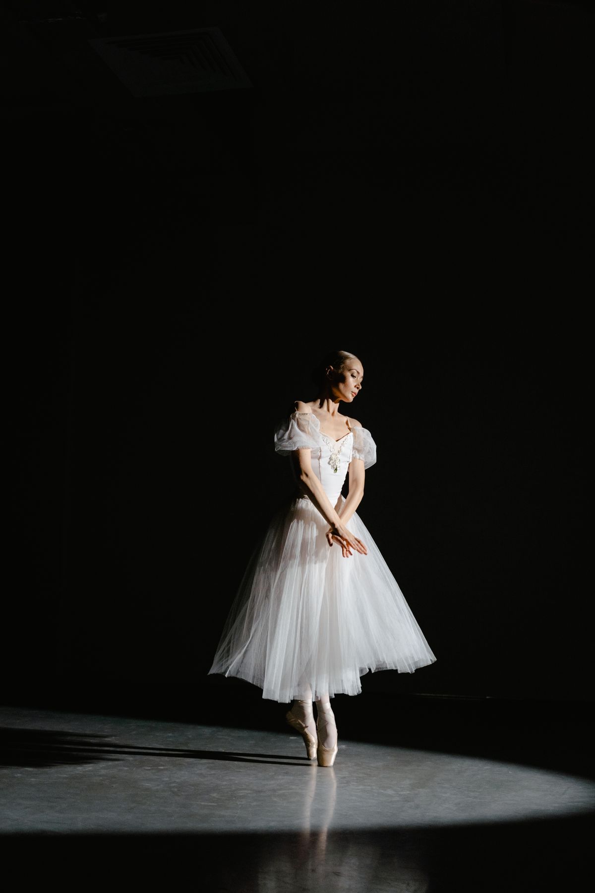 Ballerina in a white dress under a spotlight