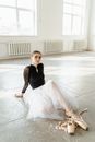 Woman in Black Long Sleeve Shirt and White Skirt Sitting on Floor