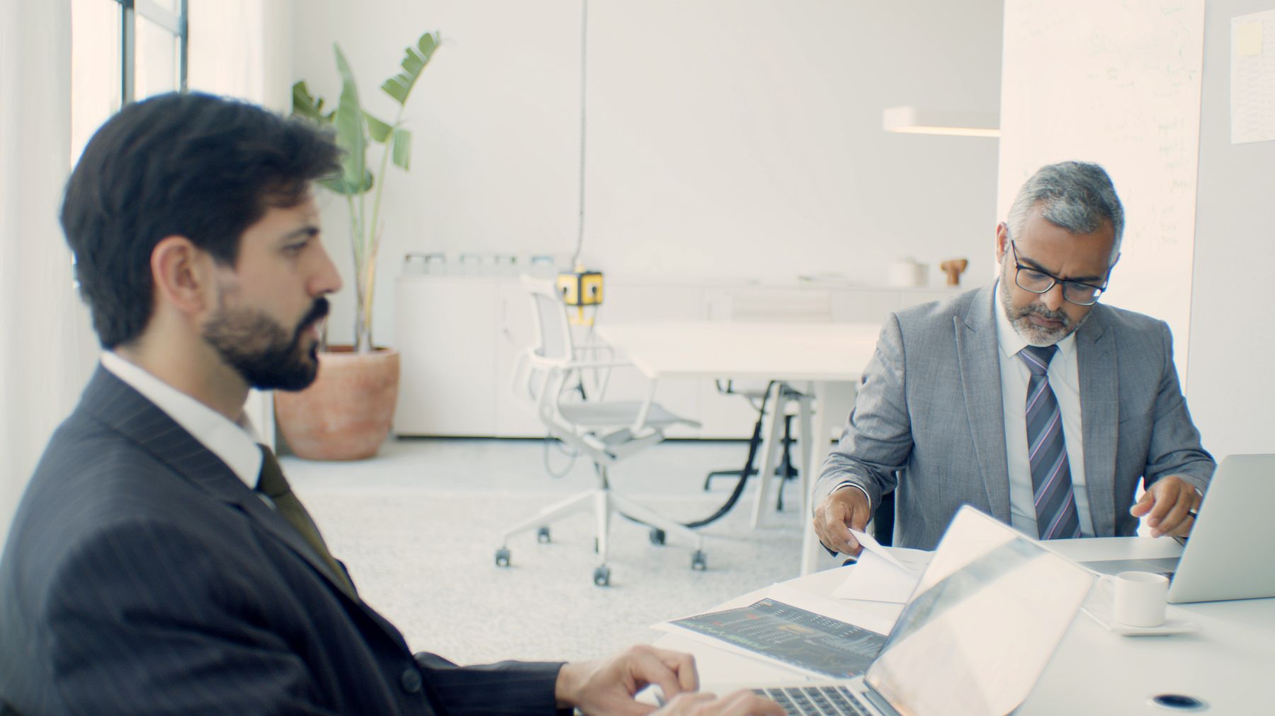 Dos profesionales consultando documentación técnica en sus portátiles