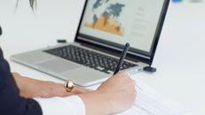 Person Holding Black Pen and Macbook Pro