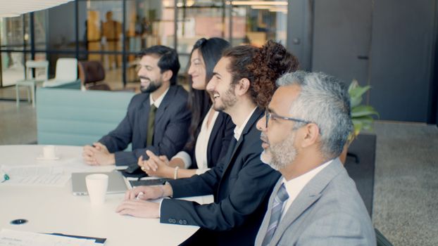 A diverse group of professionals engaged in a meeting inside a modern office.