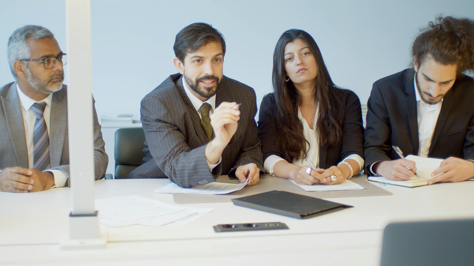 A diverse group of professionals in a modern office during a business meeting in Portugal.