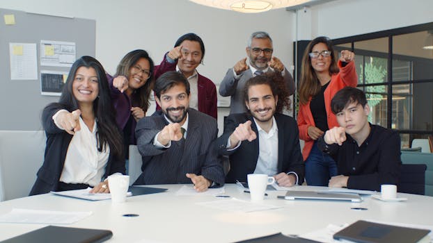 A diverse group of colleagues smiling and pointing in a modern office setting, promoting teamwork.