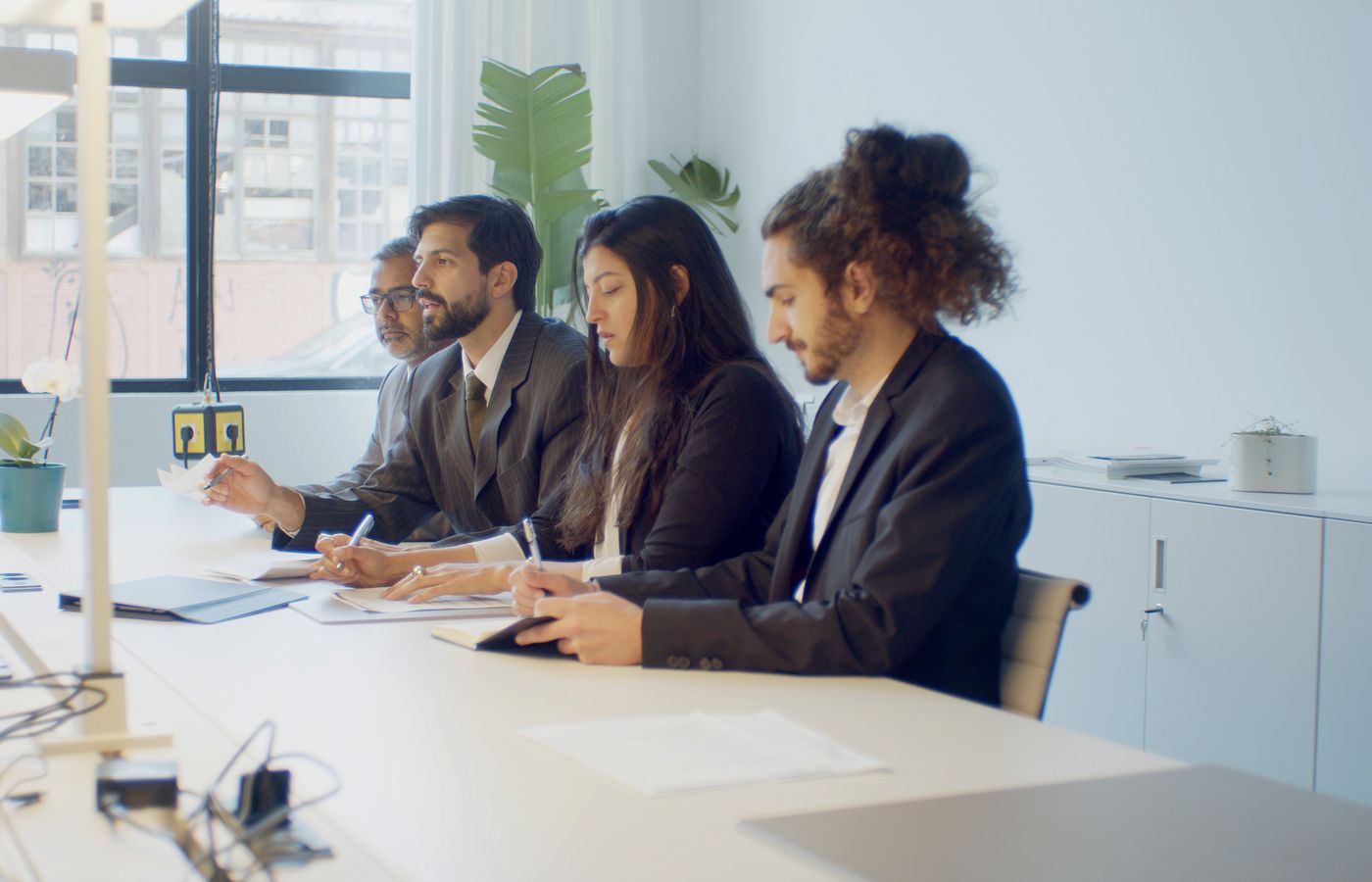 A diverse group of professionals in a business meeting discussing strategy indoors.