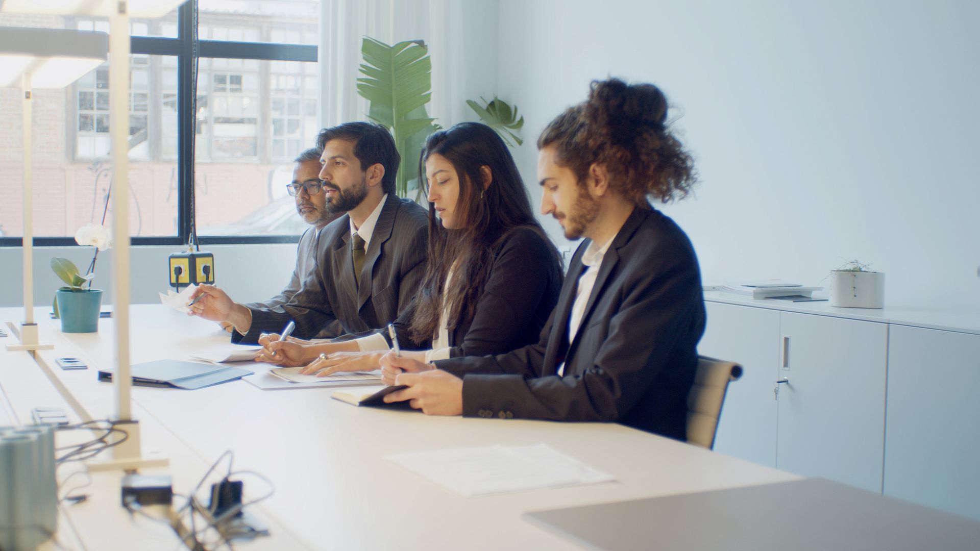 A diverse group of professionals in a business meeting discussing strategy indoors.