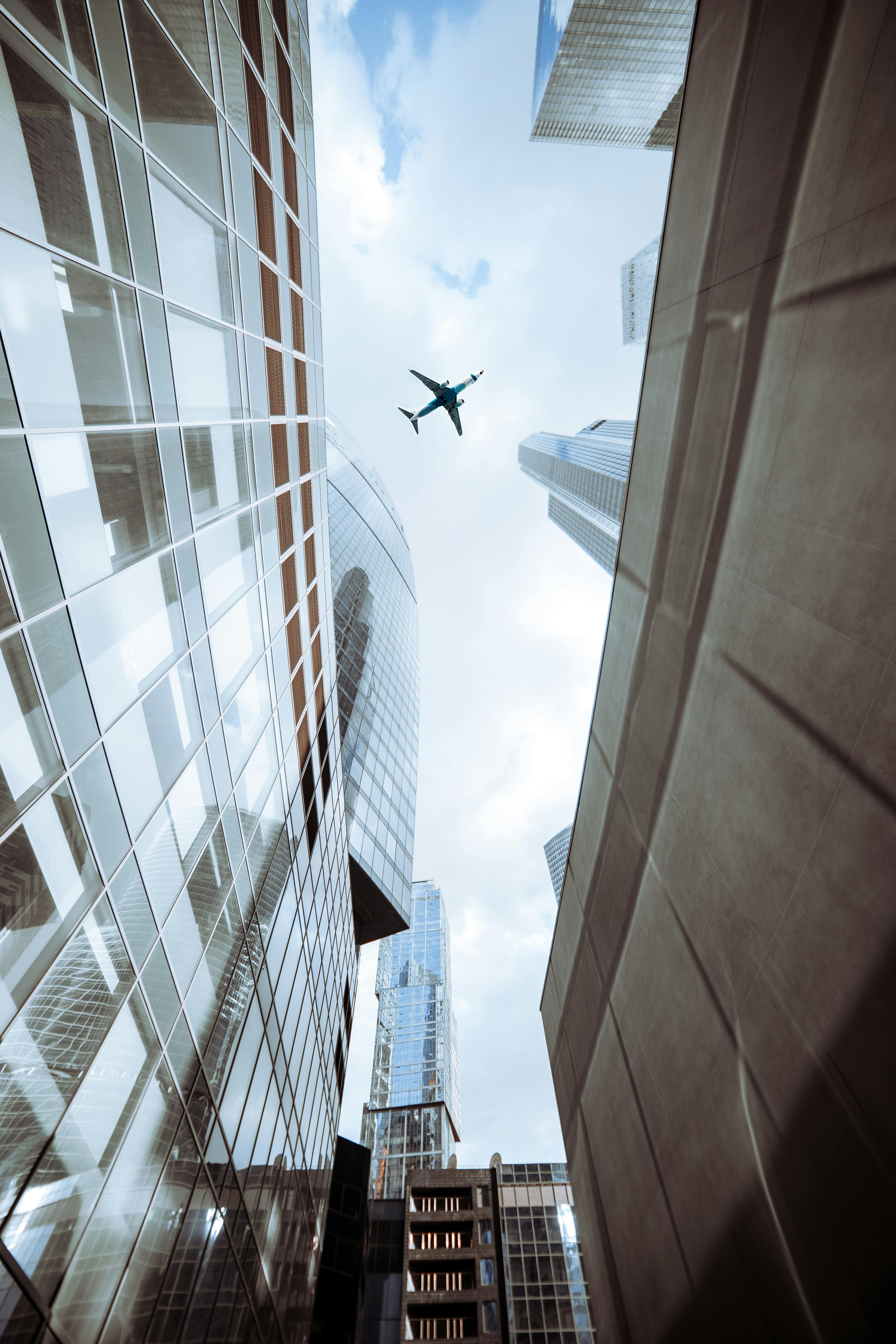 airplane flying above buildings