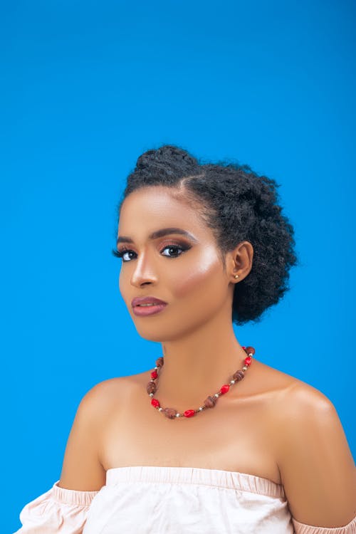 Gratis lagerfoto af afroamerikansk kvinde, blå baggrund, halskæde