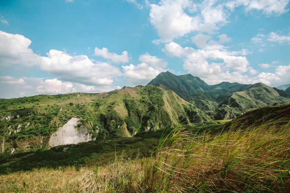 A scenic view of lush green mountains with a clear blue sky, perfect for nature lovers.